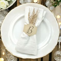 the table is set with white plates and silverware, napkins, and candles