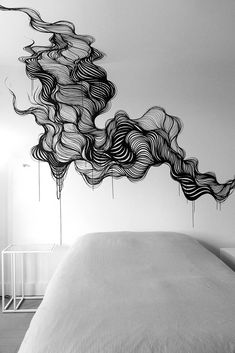 black and white photograph of a bed with wavy hair blowing in the air above it