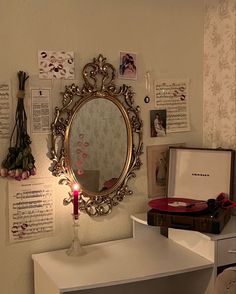 a mirror on the wall above a table with a candle and other items around it