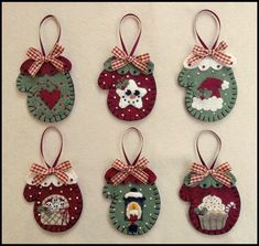 four christmas ornaments are hanging on the wall, each decorated with different designs and colors