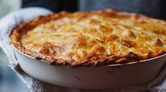 a close up of a pie in a pan on a table with a towel around it