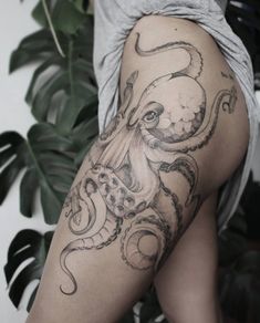 an octopus tattoo on the back of a woman's leg