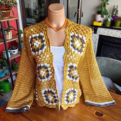 Embrace the sunny days with our Handmade Yellow Crochet Cardigan, a perfect blend of bohemian charm and summer elegance. This lightweight cardigan is meticulously hand-knitted from soft acrylic yarn, offering a breezy yet stylish option for your summer wardrobe. Elegant Design and Craftsmanship: Experience the unique beauty of our floral pattern crochet cardigan, crafted in vibrant mustard yellow hues that add a touch of sunshine to any outfit. The intricate hand-knit detailing showcases the ski Bohemian Crochet V-neck Cardigan, Bohemian V-neck Crochet Cardigan, Handmade Bohemian Spring Cardigan, Spring Bohemian Crochet Top With Granny Square, Handmade Bohemian Crochet Long Sleeve Top, Bohemian Crochet Top With Granny Square For Spring, Summer Crochet Long Sleeve Cardigan, Bohemian Granny Square Crochet Top For Spring, Bohemian Crochet Top With Crochet Trim For Fall