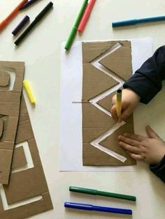 a child is making art with crayons and construction paper