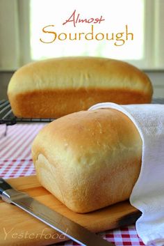 a loaf of bread sitting on top of a wooden cutting board next to a knife