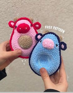 two small crocheted animals are being held up