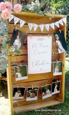 an old wooden box with pictures hanging from it and some flowers on the outside wall