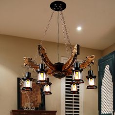 a chandelier hanging from the ceiling in a living room with wood and glass shades