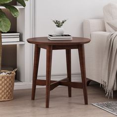 a living room with a couch, chair and table next to a potted plant