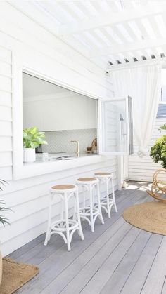 the sun is shining through the white curtains on the porch area with stools and tables