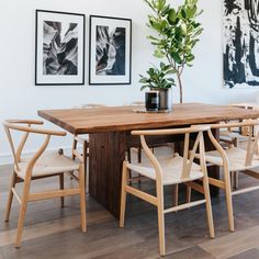 a dining room table with chairs and a potted plant on it's end