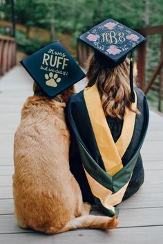 a dog wearing a graduation cap and gown sitting next to a cat on a deck