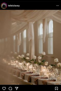 a long table with candles and flowers in vases next to each other on it