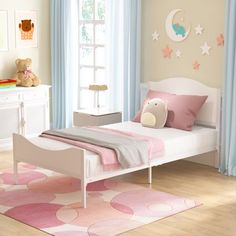 a small child's bedroom with pink and white decor, teddy bear on the bed