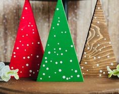 three wooden christmas trees sitting on top of a table