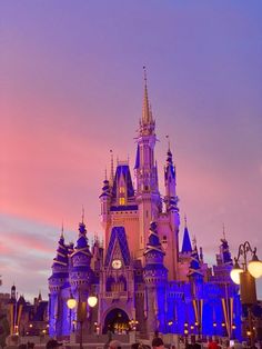 people standing in front of a castle at dusk