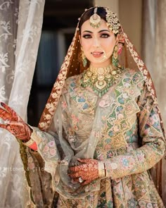 a woman wearing a bridal outfit and jewelry