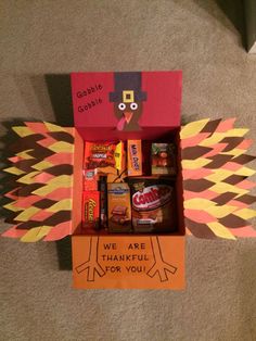 an open box with candy and candies in it on the floor next to a carpet