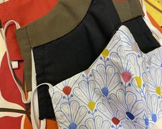 three different colored bags sitting next to each other on top of a table with an orange, yellow, and blue bag