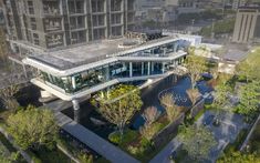 an aerial view of a building in the middle of a city with lots of trees