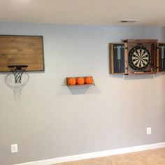 a living room filled with furniture and a dart on the wall next to a basketball hoop