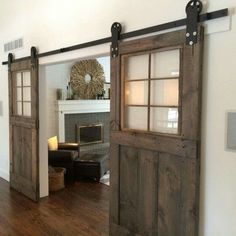 an open door leading to a living room with a fireplace in the corner and a chair next to it