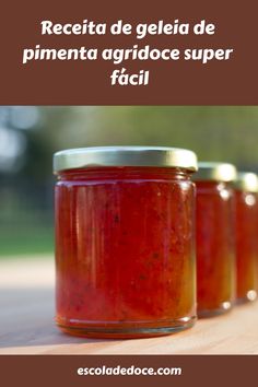 three jars filled with red sauce sitting on top of a wooden table