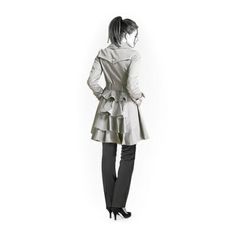 a woman standing in front of a white wall wearing a trench coat and black pants