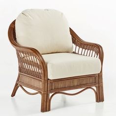 a wicker chair with a white cushion on it's back and armrests