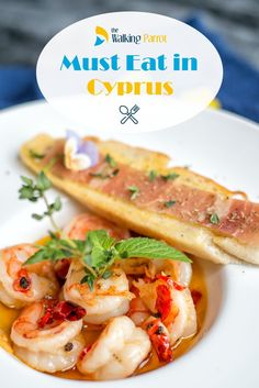 a white plate topped with shrimp and bread