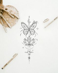 a drawing of a butterfly on paper next to pens and scissors