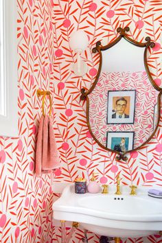 a bathroom with pink and orange wallpaper