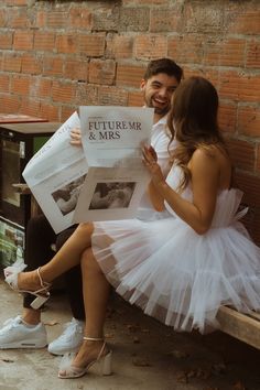 a man and woman are sitting on a bench reading the news paper, while they both look at each other's faces