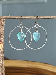 These gorgeous earrings are made using hand forged, hammered, Sterling Silver hoop frames. The center of the hoop hangs a wire wrapped faceted Blue Chalcedony shield briolette. These earrings are finished off with sturdy Sterling Silver ear wires and they measure approximately 1.75 inches from earlobe to the end of the hoop frame. The hoops measure approx 30mm in diameter. All jewelry pieces are thoroughly washed and sanitized prior to packaging for shipment. Each item comes neatly packaged in a jewelry box that is ready to gift to yourself or a loved one! Please feel free to contact me if you have any questions or have a custom request. We are currently accepting custom order request! Cheap Blue Wire Wrapped Hoop Earrings, Hoop Frame, Hammered Sterling Silver, Blue Chalcedony, Silver Gifts, Sterling Silver Hoops, Jewelry Earrings Hoops, Gorgeous Earrings, Silver Hoops