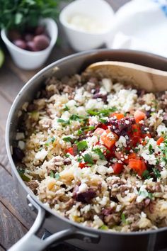 a pot filled with rice and vegetables on top of a wooden table