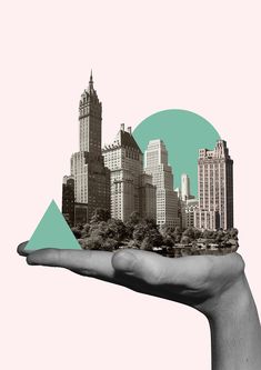 a person's hand holding an image of a city