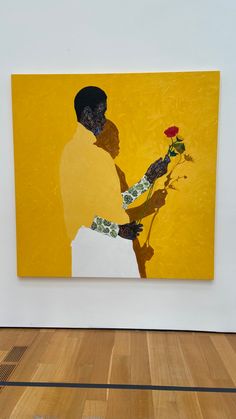 a painting on the wall with a person holding a flower in front of it and a yellow background