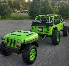 two lime green jeeps parked in a parking lot with trees in the back ground