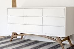 a white dresser sitting on top of a rug