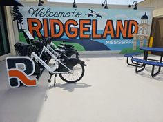 two bikes parked next to each other in front of a sign that reads welcome to ridgeland mississippi