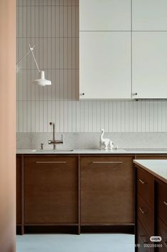 a kitchen with wooden cabinets and white counter tops, along with an animal figurine on the sink