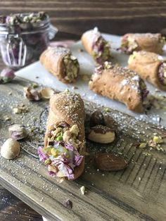 some food is laying out on a wooden table with nuts and other things around it