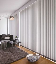 an empty living room with white vertical blinds