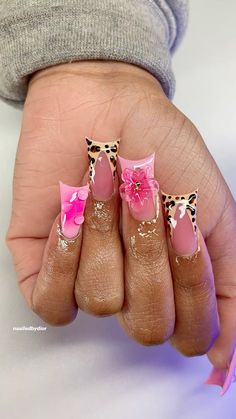 a person with pink and leopard print nail art on their nails, holding onto the palm of their hand