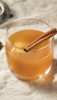 a glass filled with liquid and cinnamon sticks