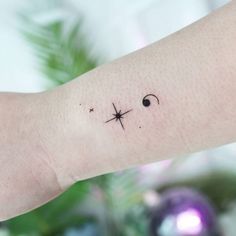 a person's arm with a small cross tattoo on it