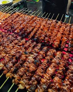 several skewered meats are being cooked on the grill