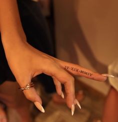 a woman's hand with the word vim tattooed on her left index finger