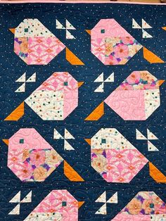 a blue quilt with pink and white fish on it's sides, in the middle