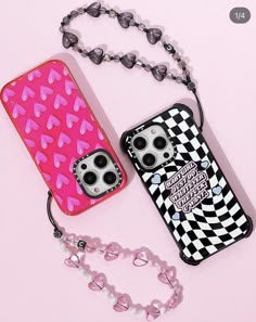 two cell phones are laying next to each other on a pink background with hearts and beads